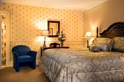 guest room with bed, desk and accent chair