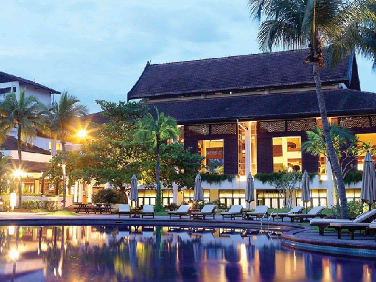 Landscape view of the hotel and sunbeds lined by the outdoor pool area at Saujana Hotel Kuala Lumpur
