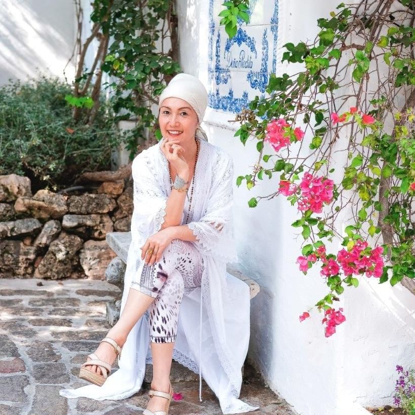 A lady sitting on a bench & posing at Marbella Club Hotel