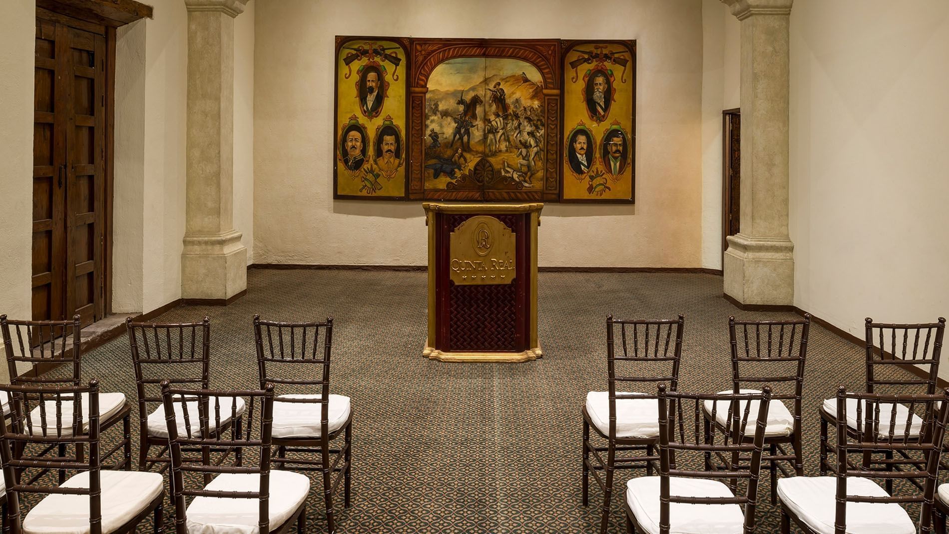 San Pedro meeting room featuring a wooden podium and historic mural artwork at Quinta Real Zacatecas