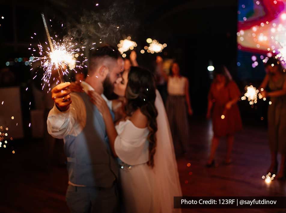 A couple kissed each other while holding a firework during a wedding party - Lexis Suites Penang