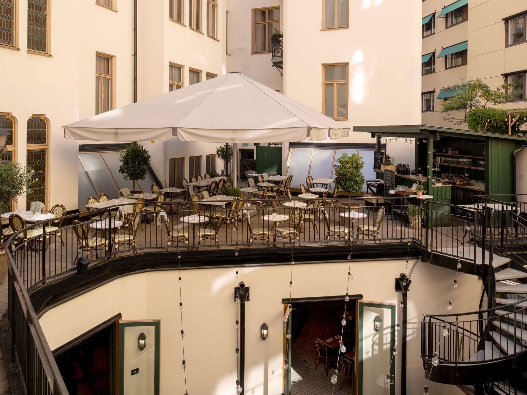 Outdoor patio with tables and chairs in Le Garden at The Sparrow Hotel