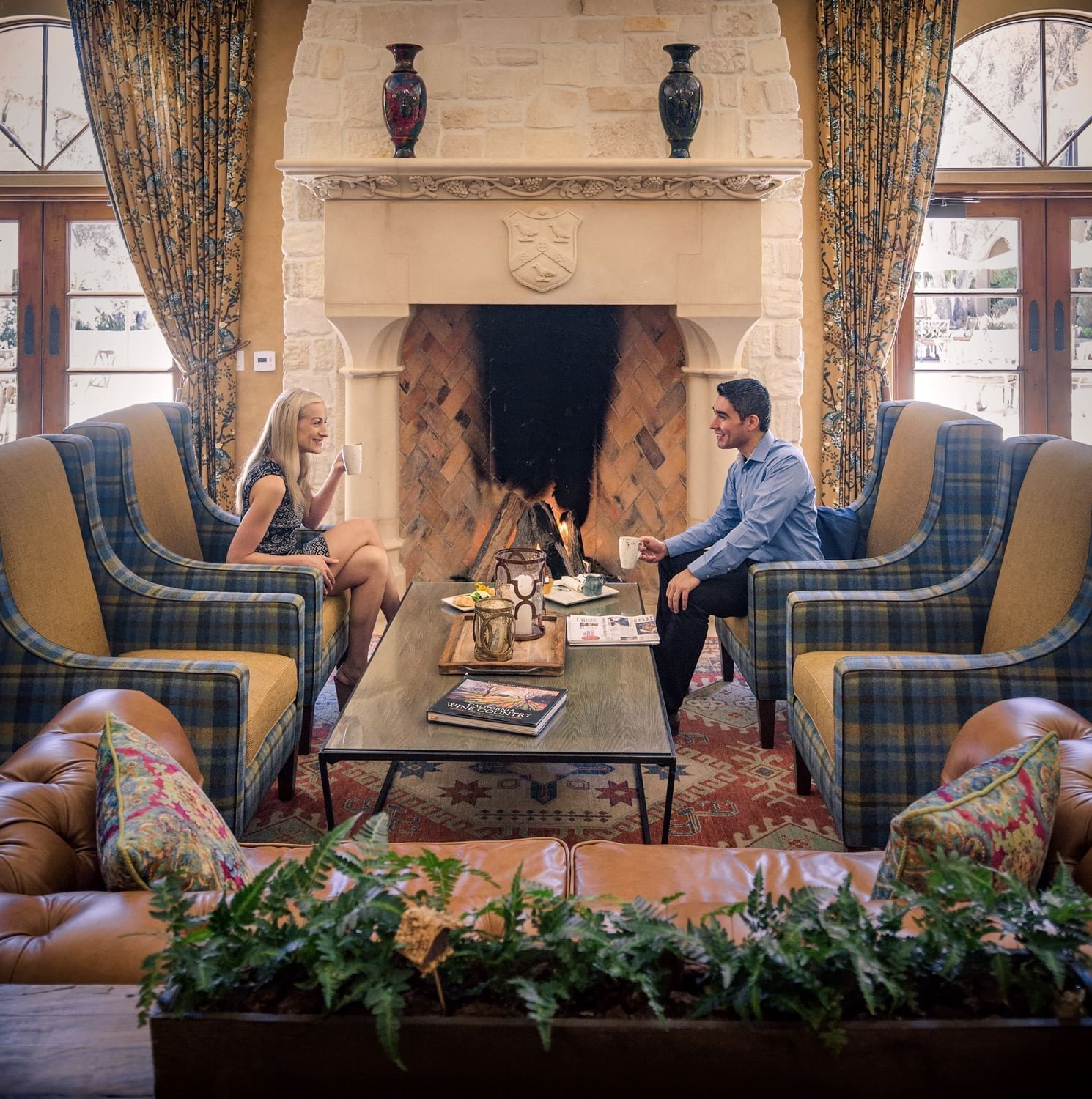Guests sitting in lounge chairs in front of fire place