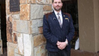 Alex Lyman the bell captain at the front door of Chateaux Deer Valley on welcoming guests.