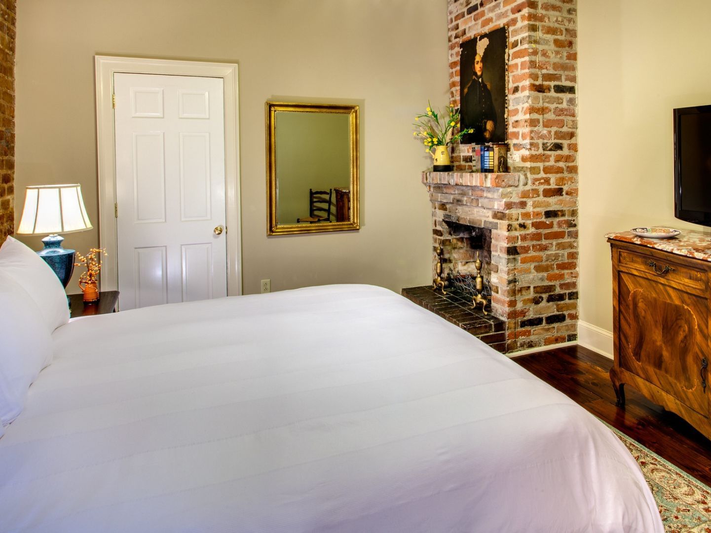 King bed with a TV in Audubon Cottage 3 at Audubon Cottages