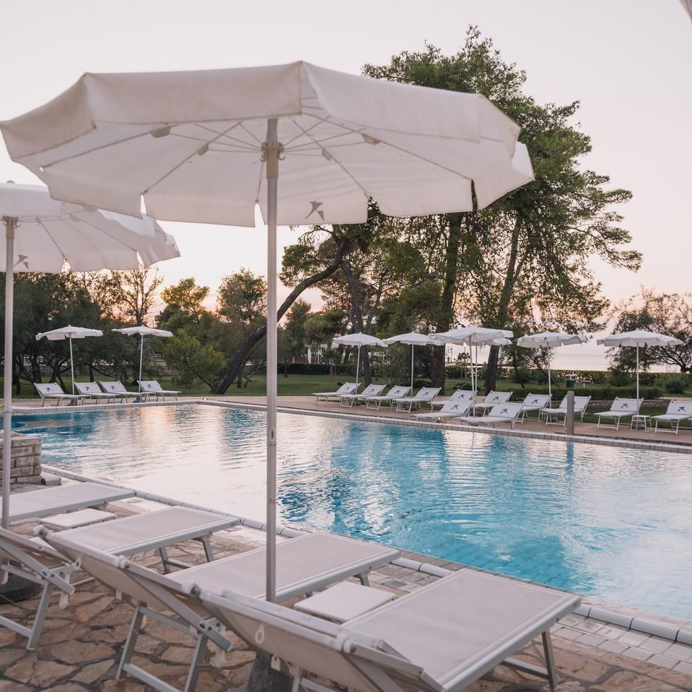 Sunbeds surrounding the outdoor pool at Falkensteiner Hotels