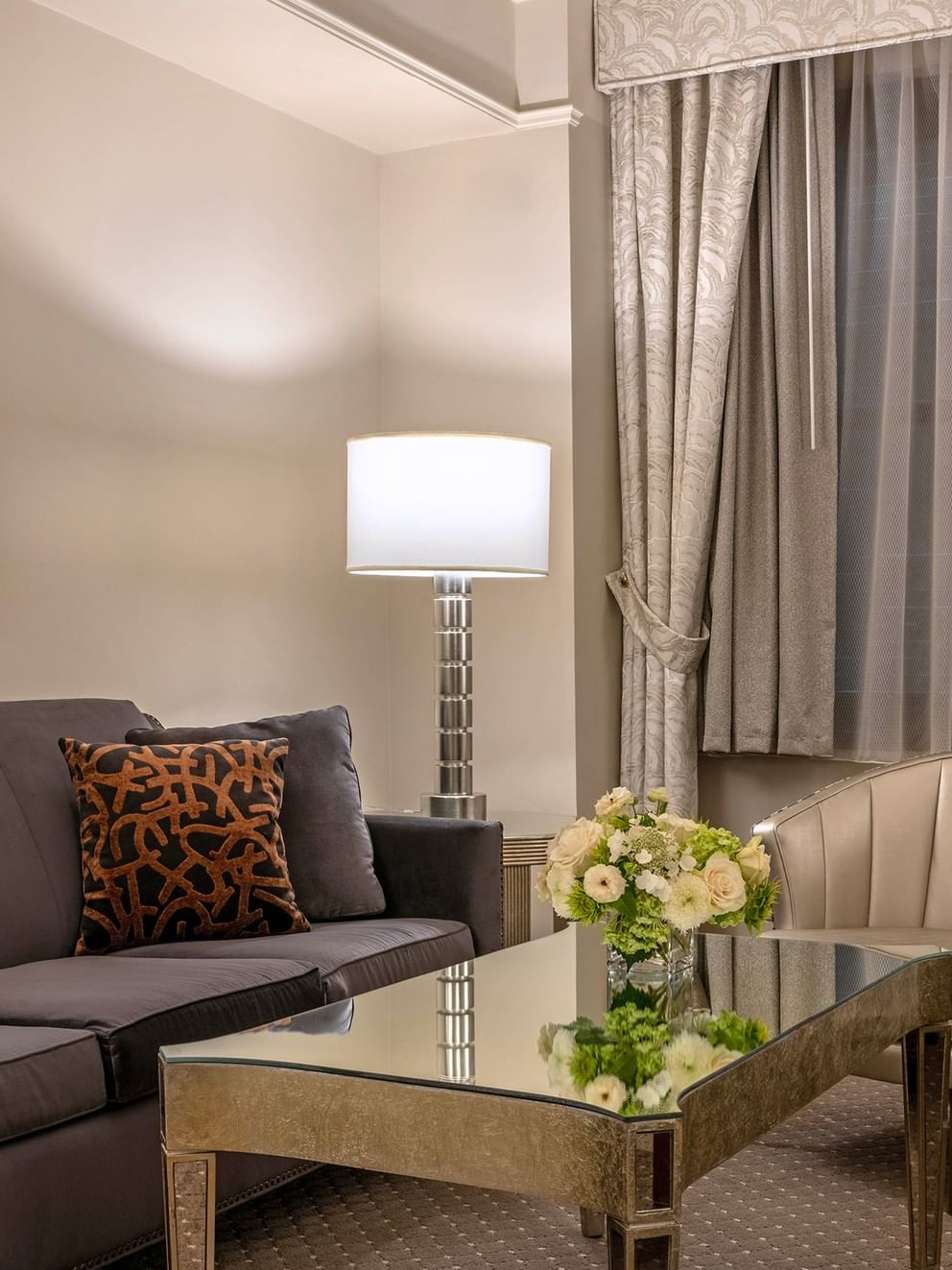 Premier Suite living area with plush sofa near window at Warwick New York