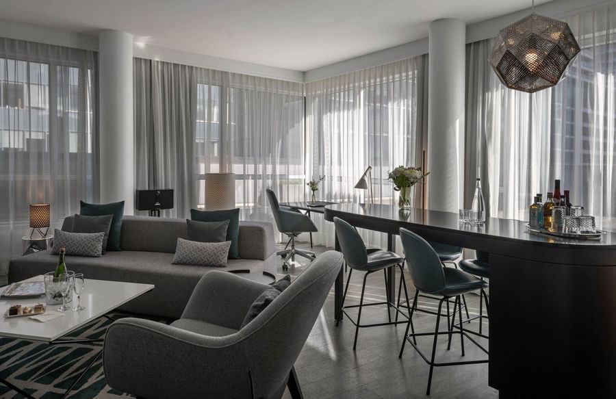 Penthouse René-Lévesque living area with plush sofa and bar counter near window at Warwick Le Crystal Montreal