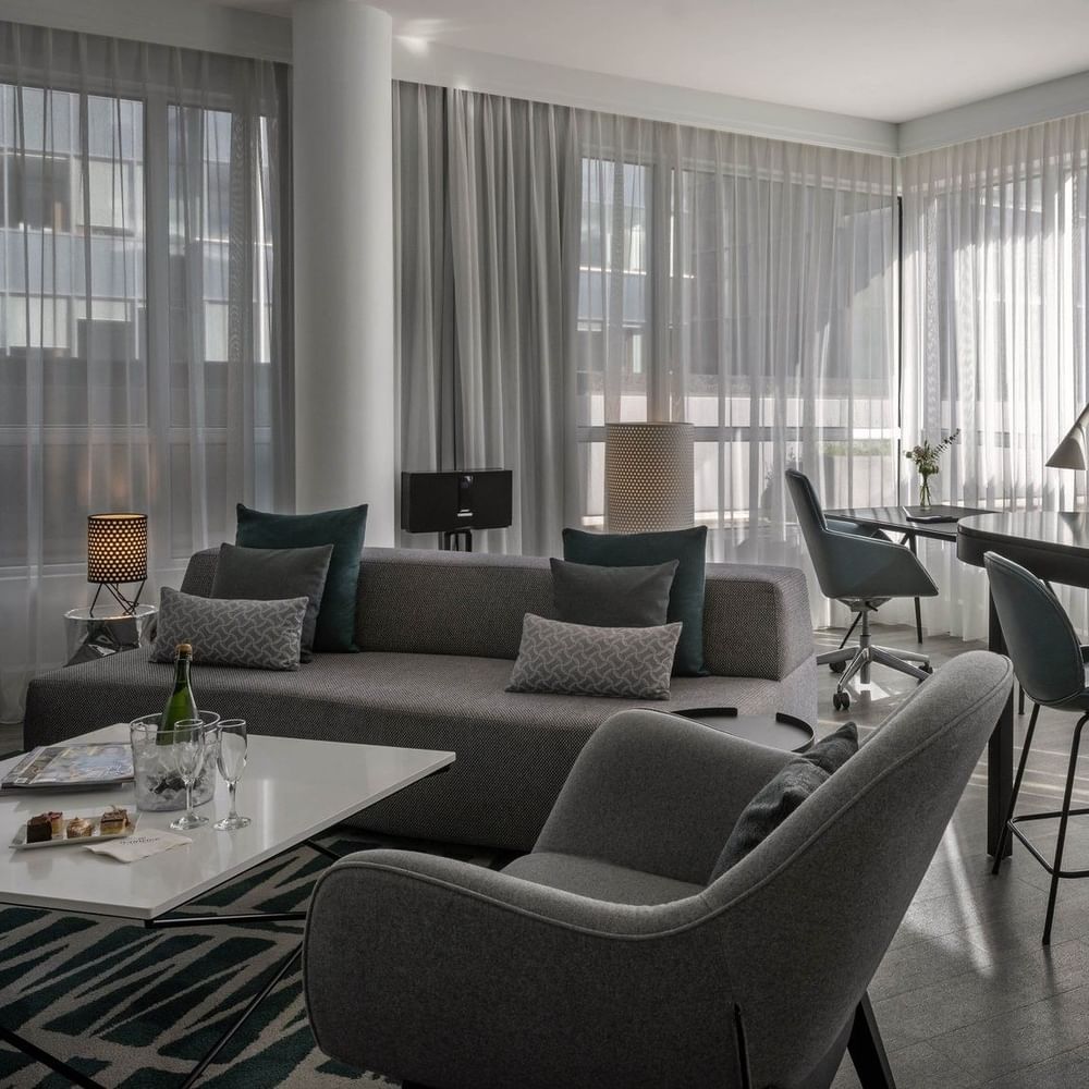 Penthouse René-Lévesque living area with plush sofa and bar counter near the window at Warwick Le Crystal Montreal