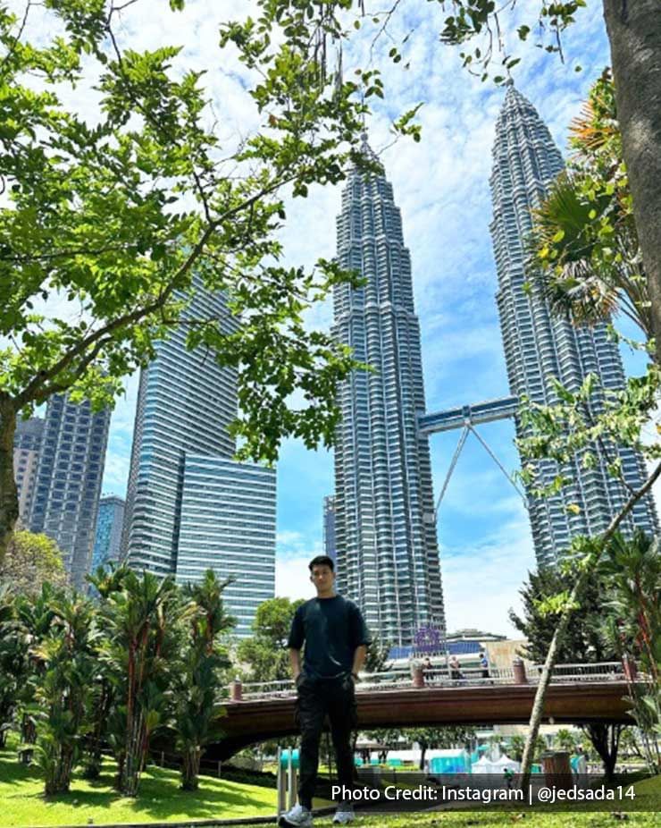 Man posing with a backdrop of The Petronas Twin Towers, a top attraction near Imperial Lexis Kuala Lumpur