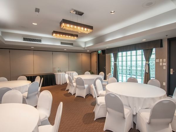 Banquet room with round tables, chandeliers and glass wall
