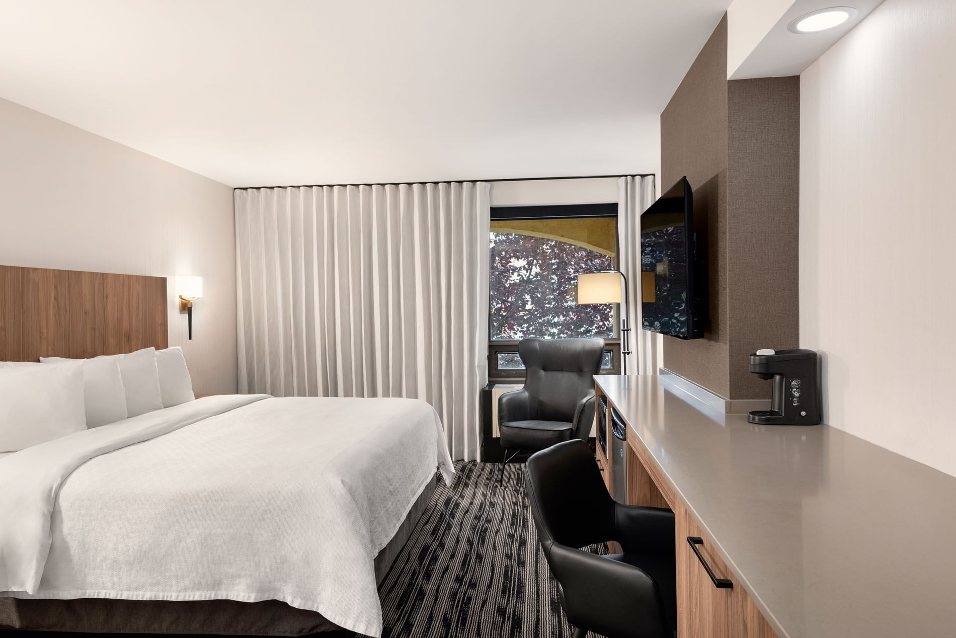 TV & workspace facing the bed in Standard One King with carpeted floors at Temple Gardens Hotel & Spa