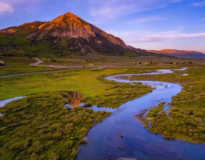 Sunset over mountain with winding river and verdant valley at Elevation Resort Spa