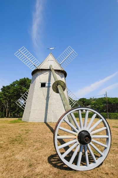 Close-up of the windmill with a wagon wheel nearby at Chatham Tides Resort