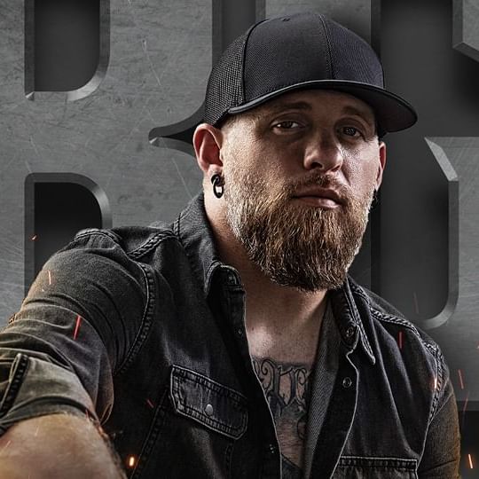 Brantley Gilbert wearing a denim shirt and black hat