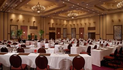 Elegantly decorated meeting hall at Hilton Santa Fe Buffalo Thunder with long tables, chairs, and lavish chandeliers