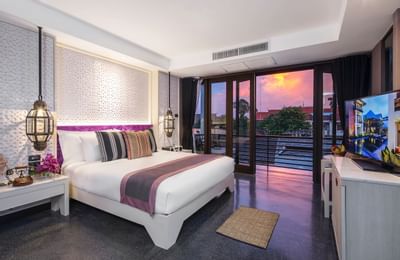 Room with a comfy bed and a beautiful view of sunset at U Hotel