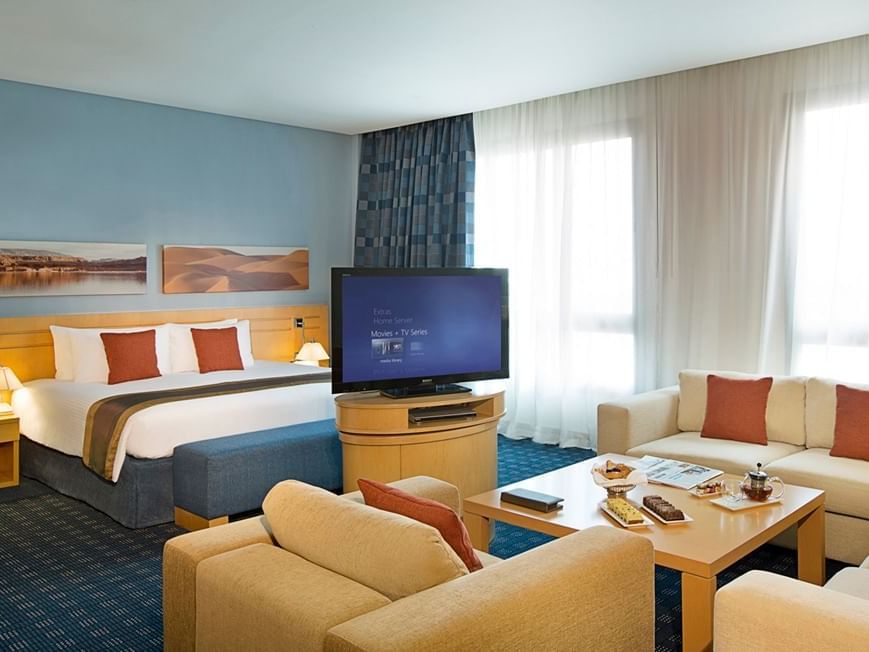 Bed & living area in Junior Suite at City Seasons Hotels
