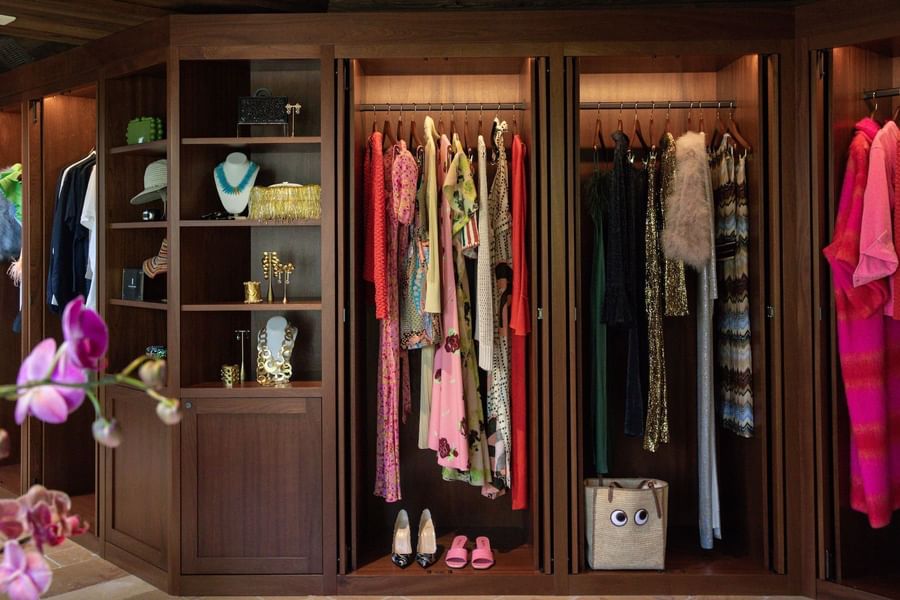 Retail store with clothes, shoes, accessories, and jewelry on shelves, and orchid flowers in the foreground.