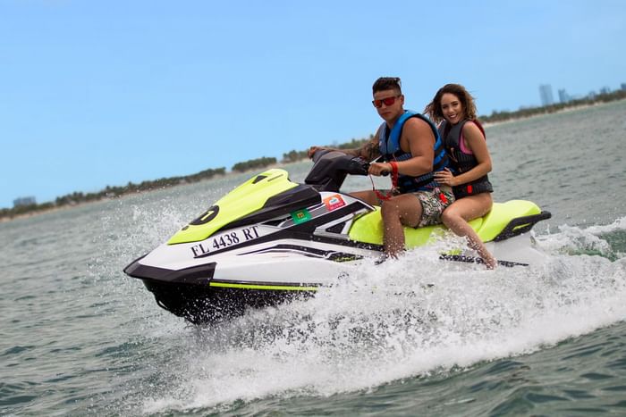 Couple enjoying a thrilling ride on a jet ski in the ocean near The Diplomat Resort