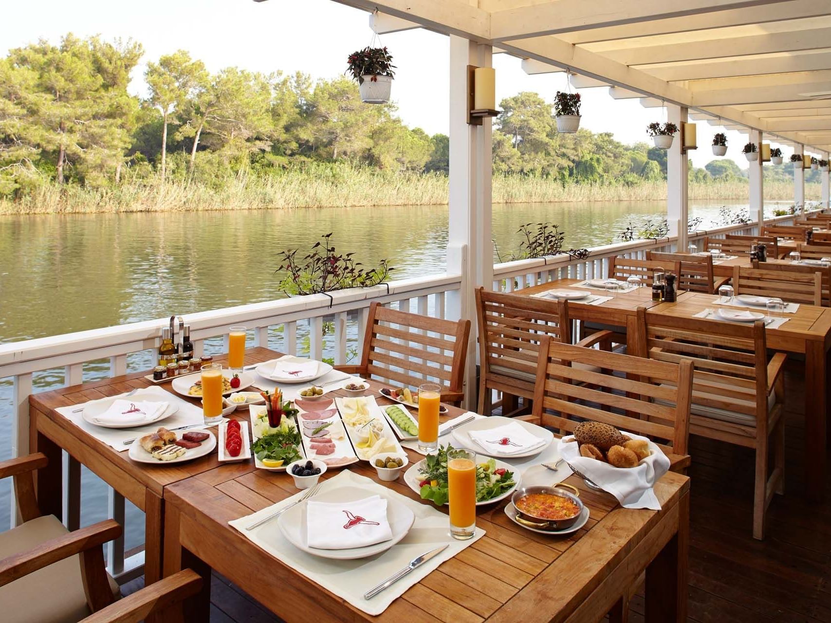 Vip Breakfast setup on wooden deck by the river at Titanic Deluxe Golf Belek