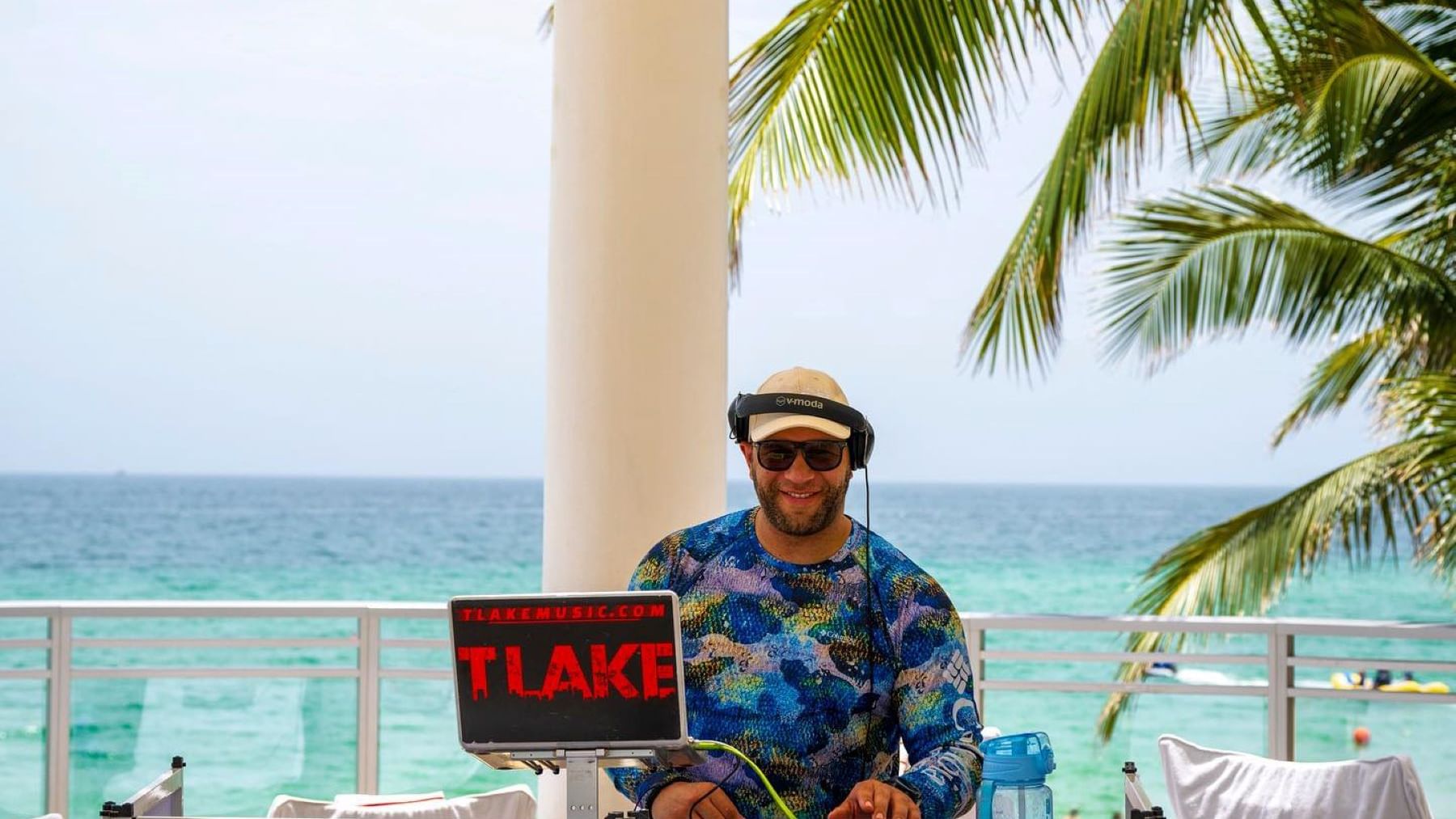 Person DJing with a laptop on a beachfront deck at Diplomat Beach Resort