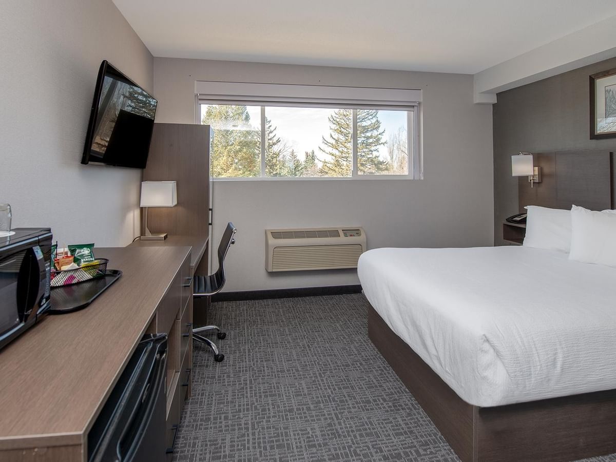 Room with desk, TV, and a queen bed.