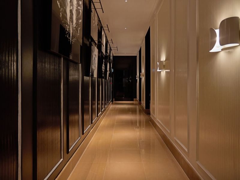 A long, illuminated hallway with modern wall sconces at The May Fair Hotel, London.