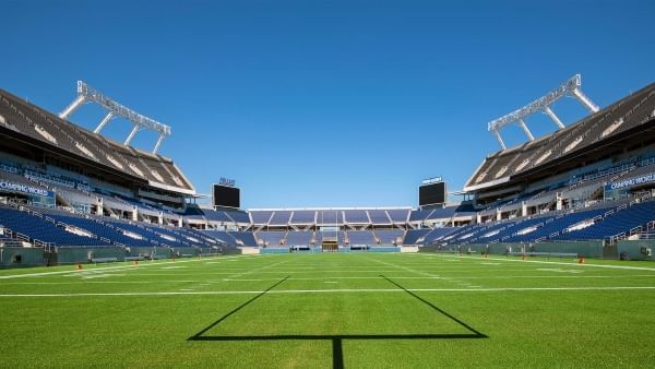 A view of a large stadium from the field on a clear, sunny day. Camping World Stadium is hosting the NFL Pro Bowl in 2025. 