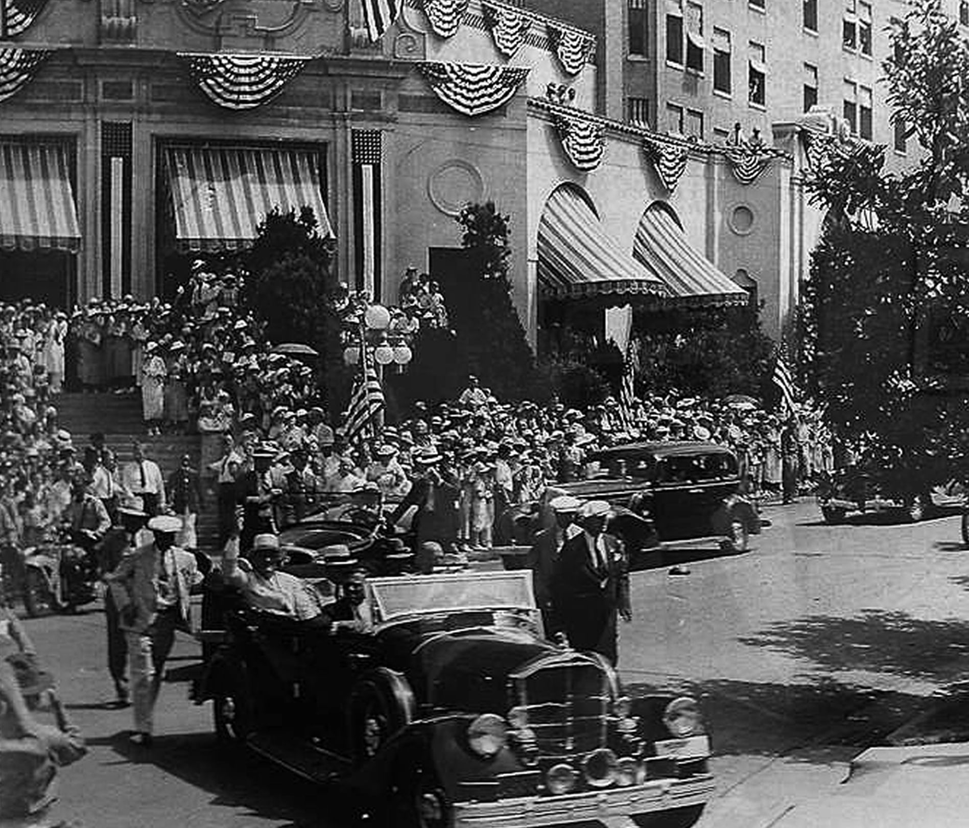 Vintage car by a crowded street under striped awnings surrounding the grand Arlington Resort Hotel & Spa entrance