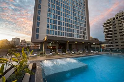 Outdoor swimming pool showcasing high-rise building views and loungers reflecting Chile hotels at Veranda Hotel
