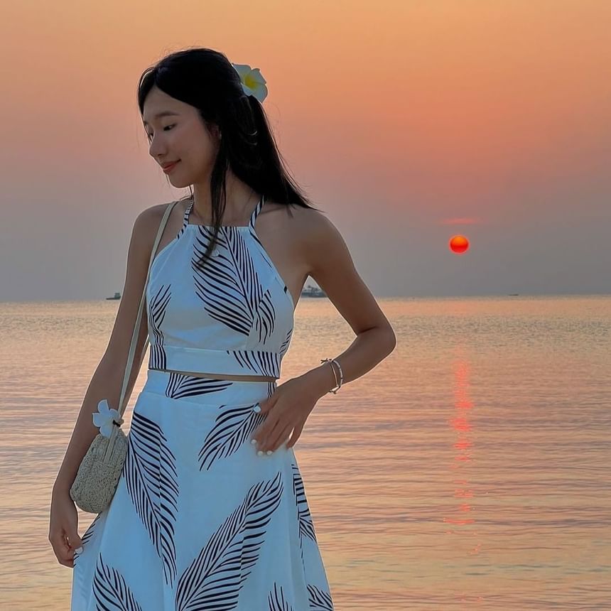 Woman in floral dress at sunset by the sea near Park Hotel Group