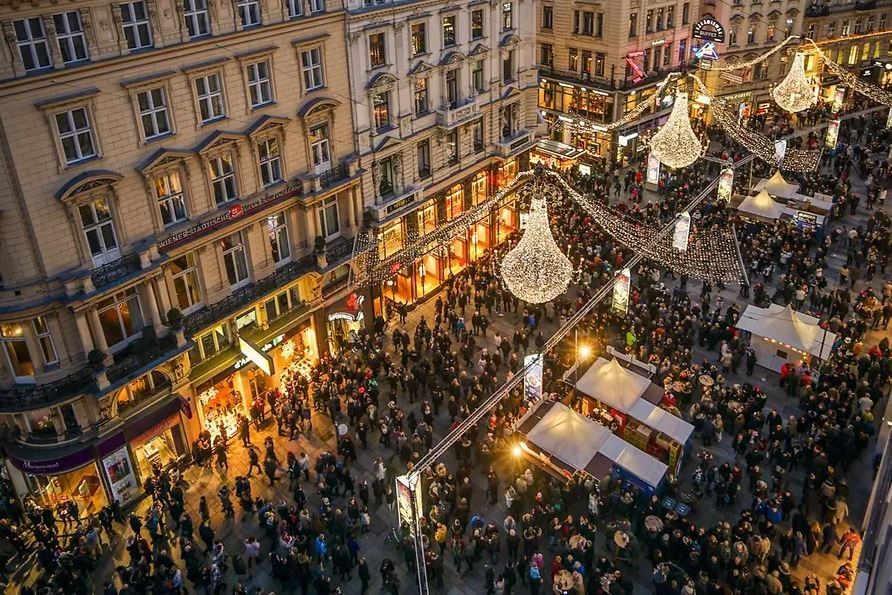 New Year’s Eve in Vienna with a festively illuminated city center, large chandelier lights and crowds in the street