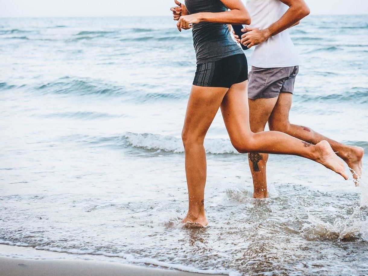 Couple jogging on the beach near Plymouth Hotel