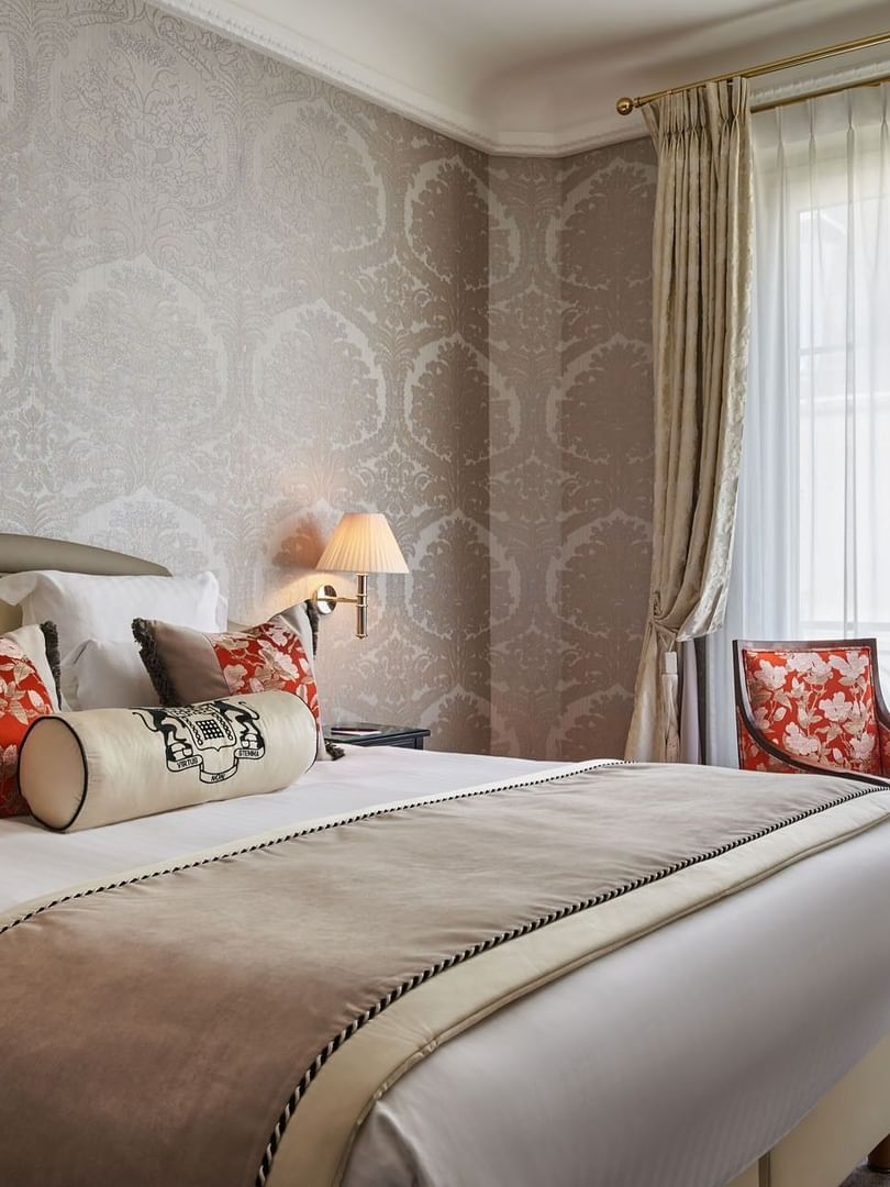 Deluxe Suite Belle Époque featuring a bed under a wall lamp and a couch near window at Hotel Westminster Paris