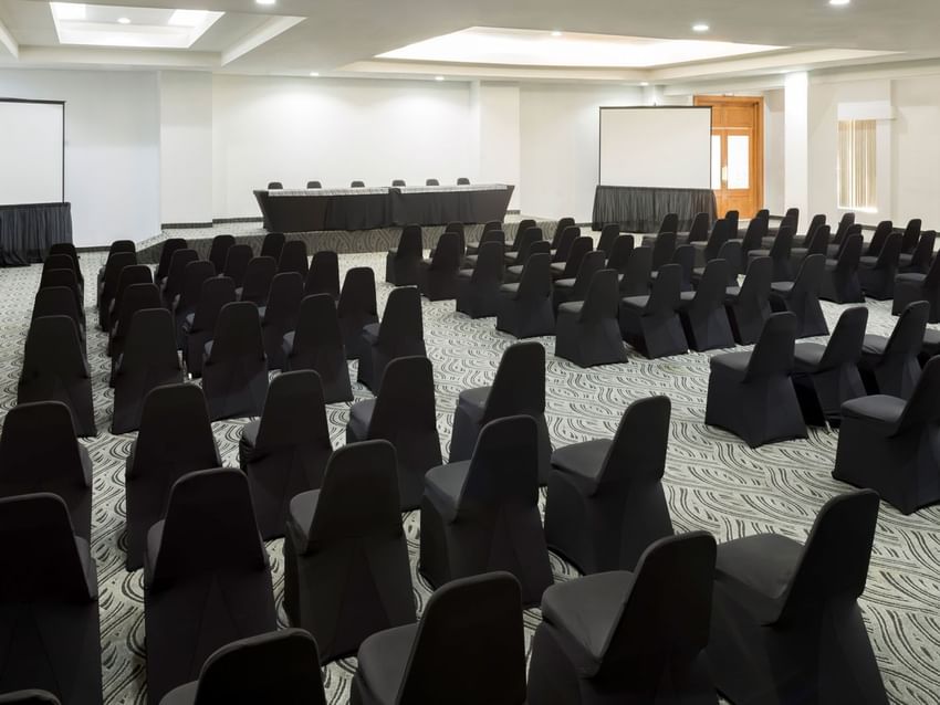 Large Bangkok conference room with many chairs and two screens at Real Inn Mexicali