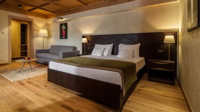 Bed and sofa with wall art in King Studio at Ana Hotels Bradul
