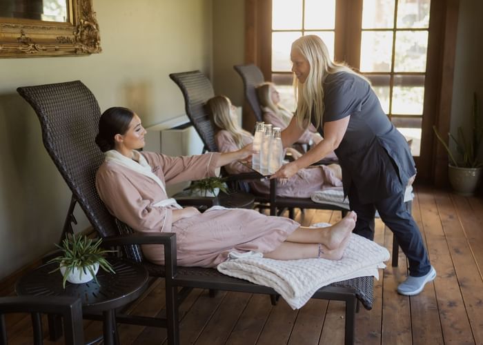 A woman receiving a dring in the spa at Stein Eriksen Lodge