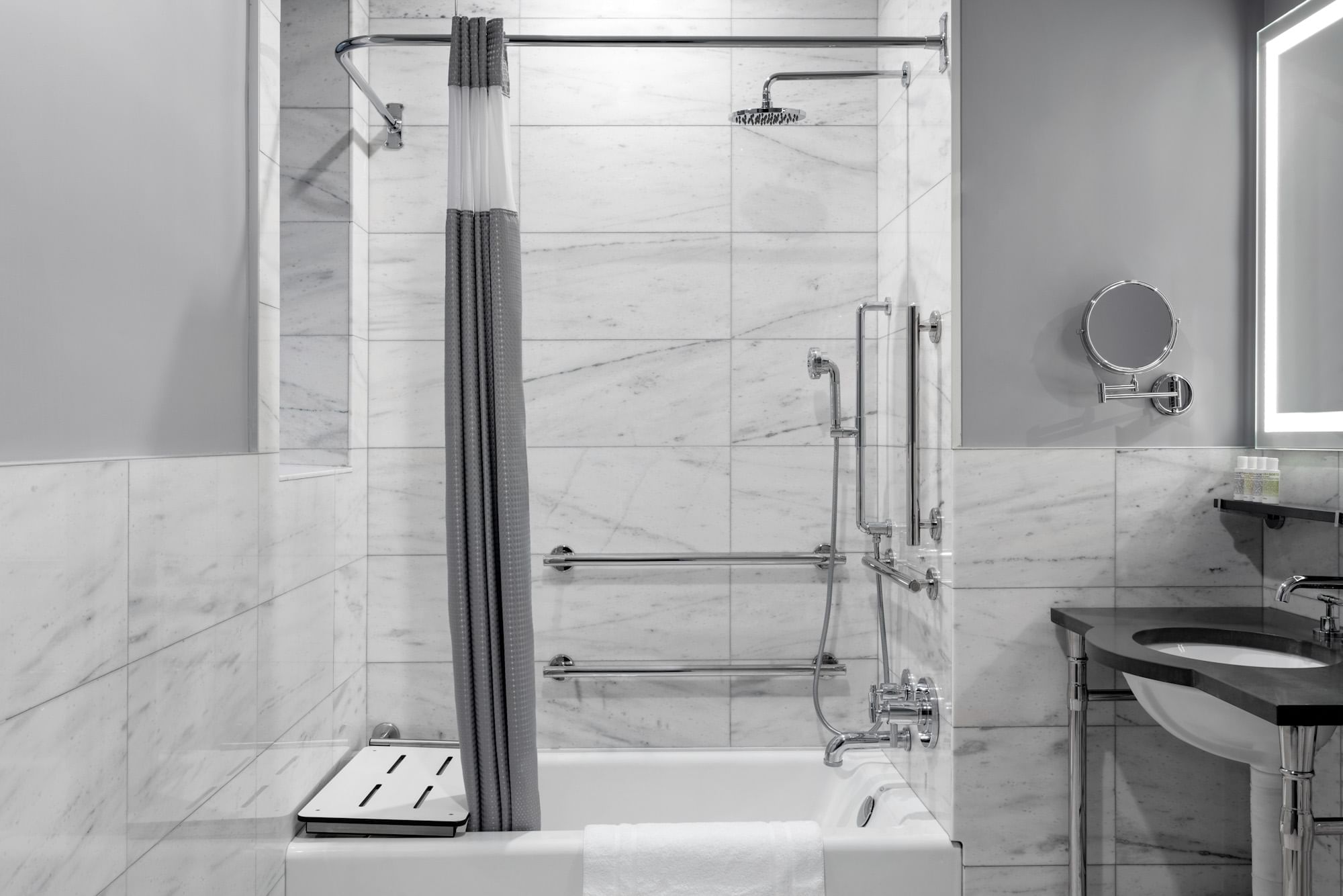 A clean and modern bathroom with a bathtub, shower, and sink.
