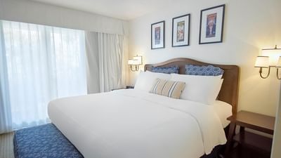 Cozy bed with carpeted floors and ottoman in Standard King Room at Pavilion Hotel Catalina Island