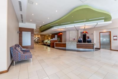 Modern lobby area with reception desk, patterned sofa and elevator at MARlNN Place Financial District
