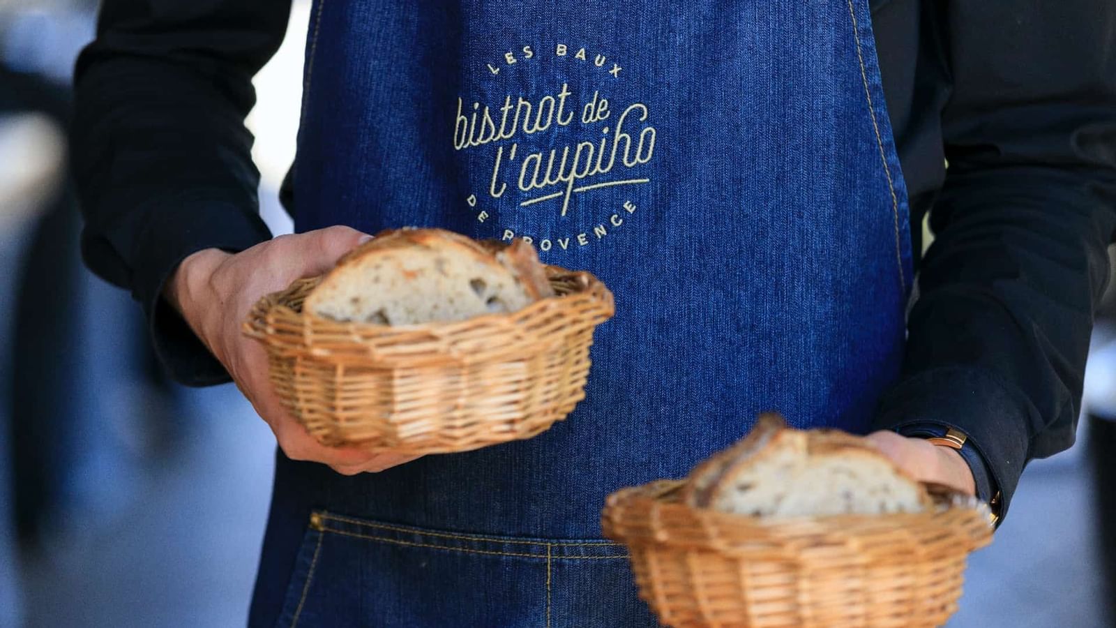A waiter holding 2 bread baskets, l'Aupiho, Domaine de Manville