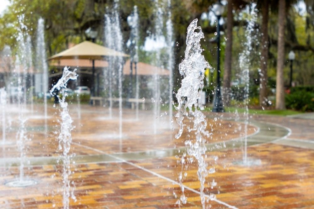 A close-up of jets of water erupting from the ground of a splash pad. 