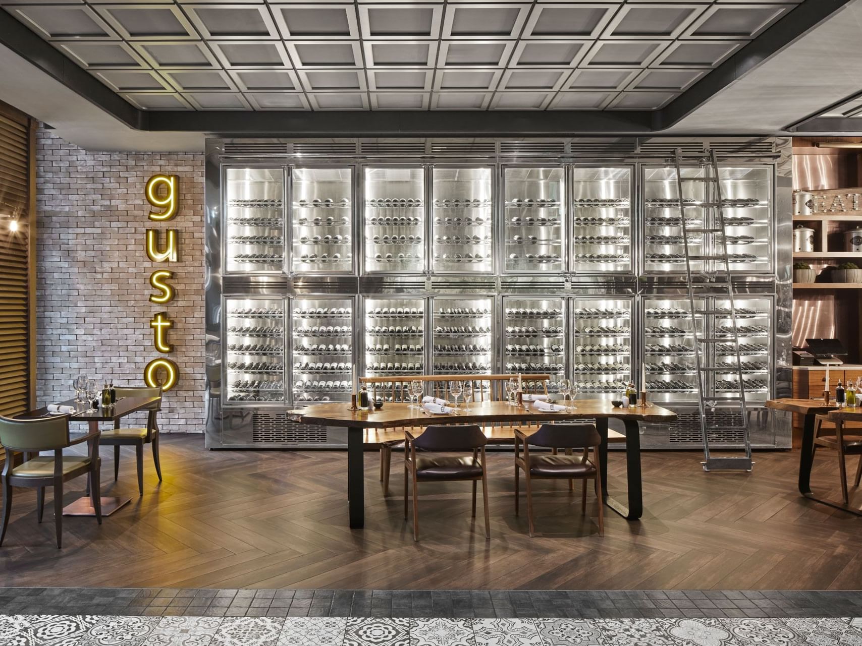 Elegantes Restaurant mit großem Weinregal, Tischen,Schriftzug an der Wand – Titanic Chaussee Berlin.