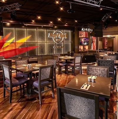 Hard Rock Cafe Panama dining area with tables and chairs, under stage lights beside a flame mural at Megapolis Hotel