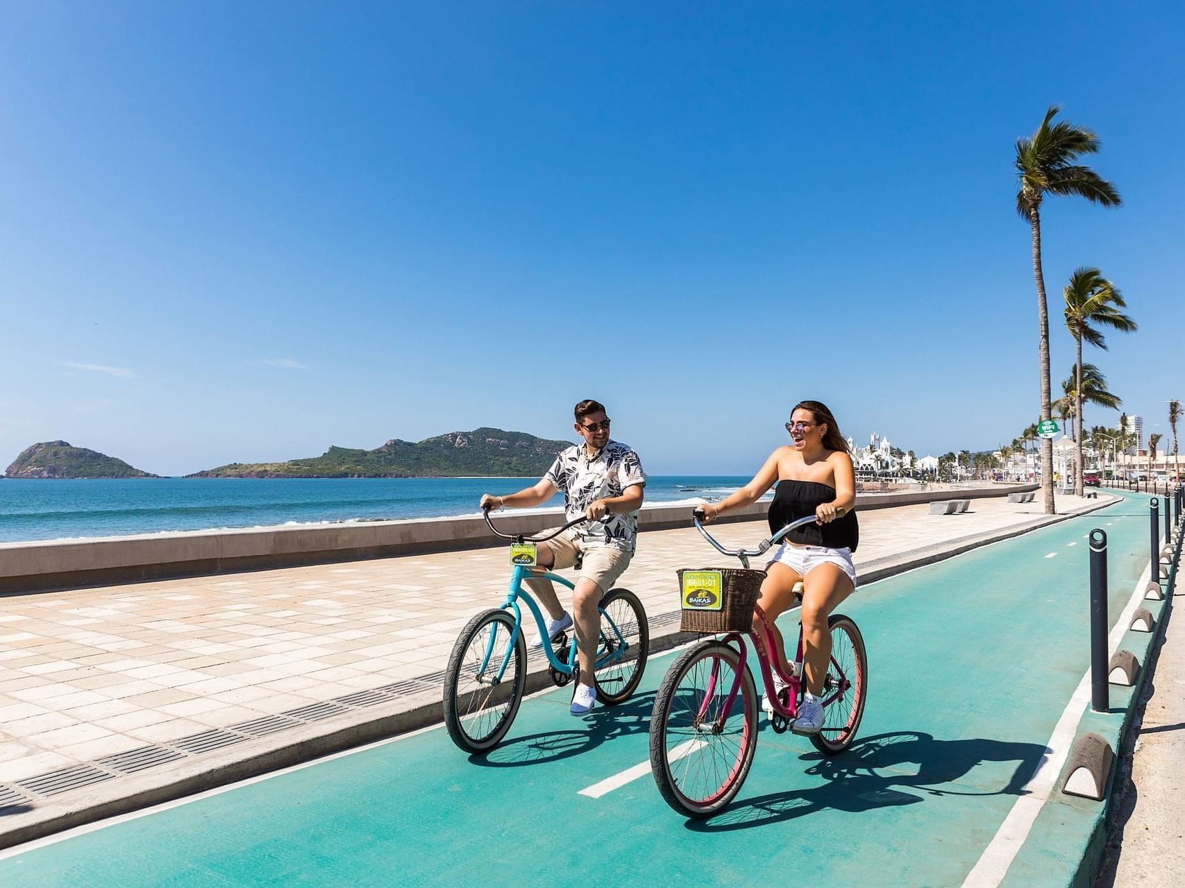 A couple riding bicycles near Viaggio Resort Mazatlan
