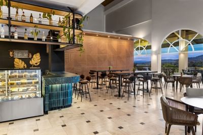 Modern restaurant with bar, dessert display, and tables at Gamboa Rainforest Resort.