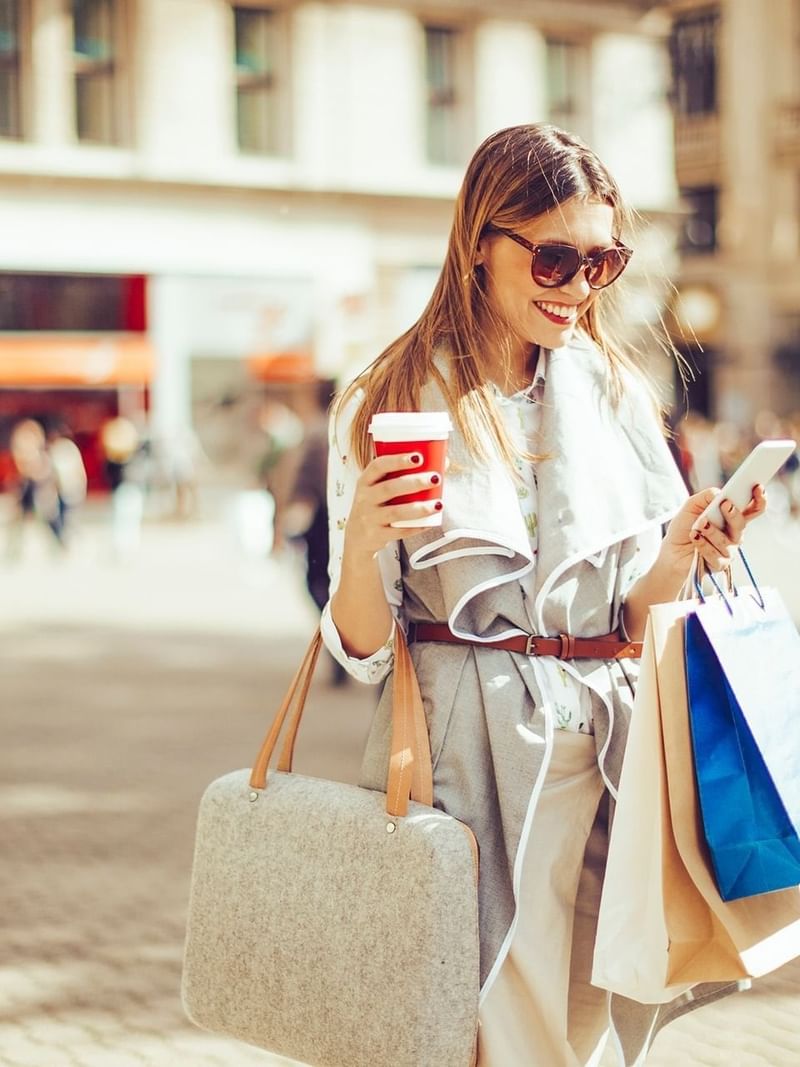 A girl browsing her phone while shopping near Warwick Allerton - Chicago