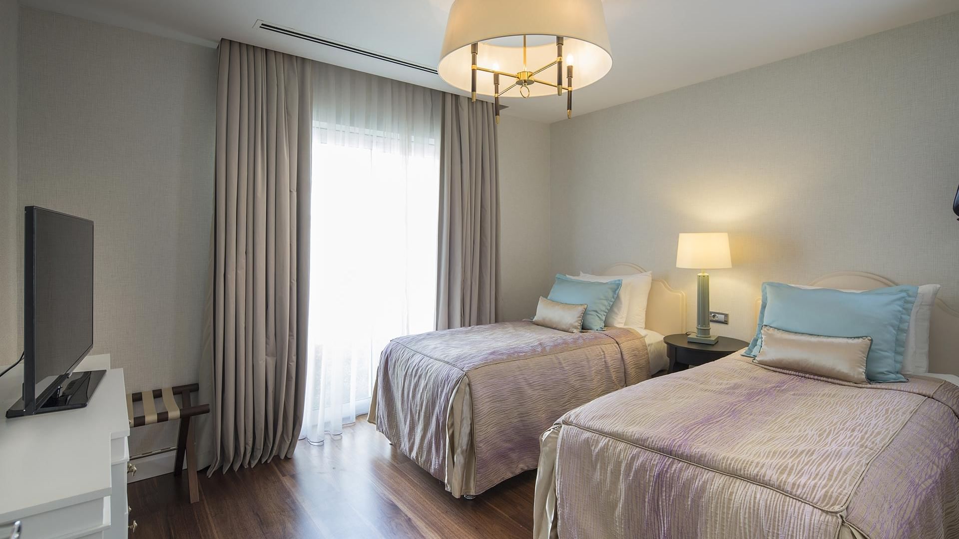 Вилла Superior в Titanic Deluxe Golf Belek — элегантный интерьер с деревянным полом и прикроватными тумбочками.