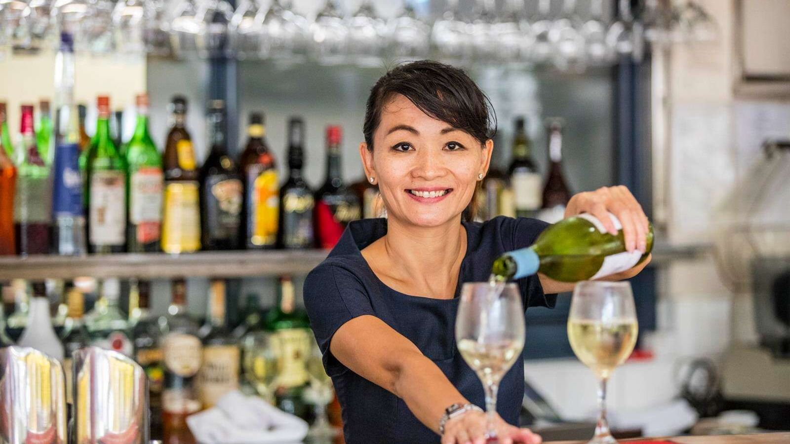 A bartender prepares drinks in a bar at Darwin Airport Hotels